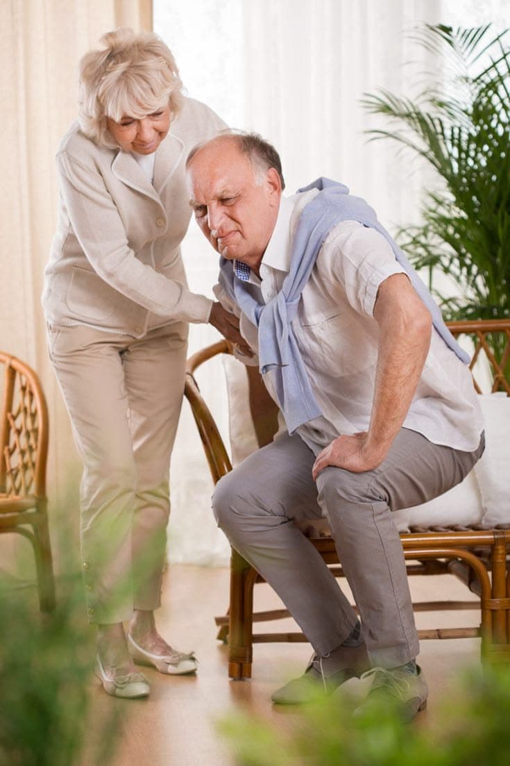 Illustrative image of an older adult experiencing back discomfort with assistance