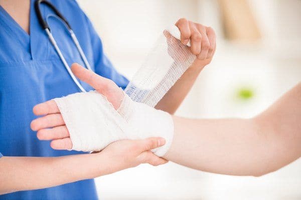 Illustrative image of a clinician dressing a person?s hand